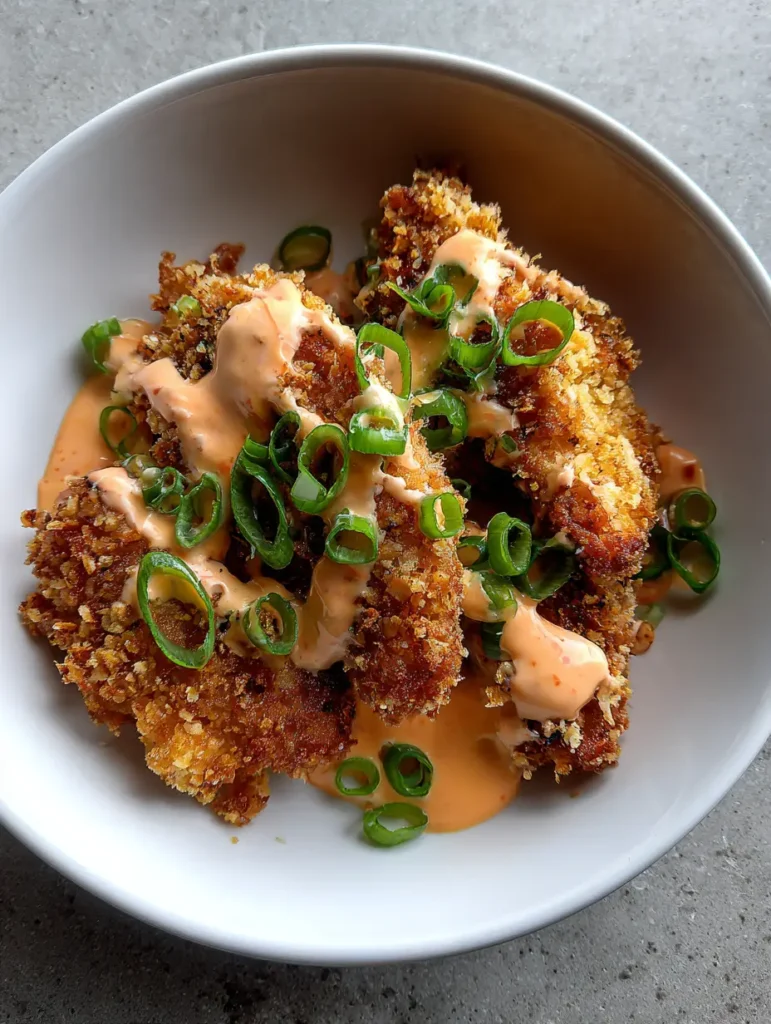 Bang Bang Chicken: Das ultimative Rezept für knuspriges Hähnchen mit Suchtfaktor 1 Bang Bang Chicken serviert mit einer cremigen Sauce und frischen grünen Frühlingszwiebeln.