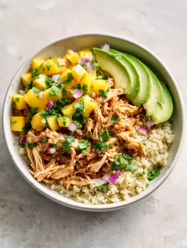 Slow Cooker Rezepte Sommer: Honig-Limetten-Hähnchen mit frischer Mango-Salsa 1 Nahaufnahme von gezupftem Hähnchenfleisch mit glänzender Honig-Limetten-Glasur und frischem Koriander.