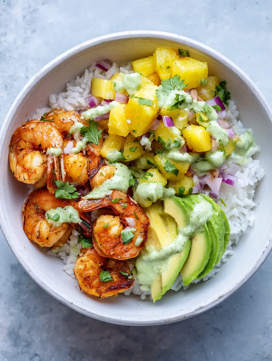 Garnelen-Reis-Bowl mit fruchtiger Ananas-Salsa & Avocado-Crema 3 Nahaufnahme einer Garnelen-Reis-Bowl mit gebratenen Garnelen und frischer Ananas-Salsa.