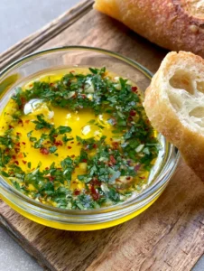 Geschmolzene Cowboy Butter Rezept mit Knoblauch, Petersilie und Chiliflocken in einer kleinen Schale.