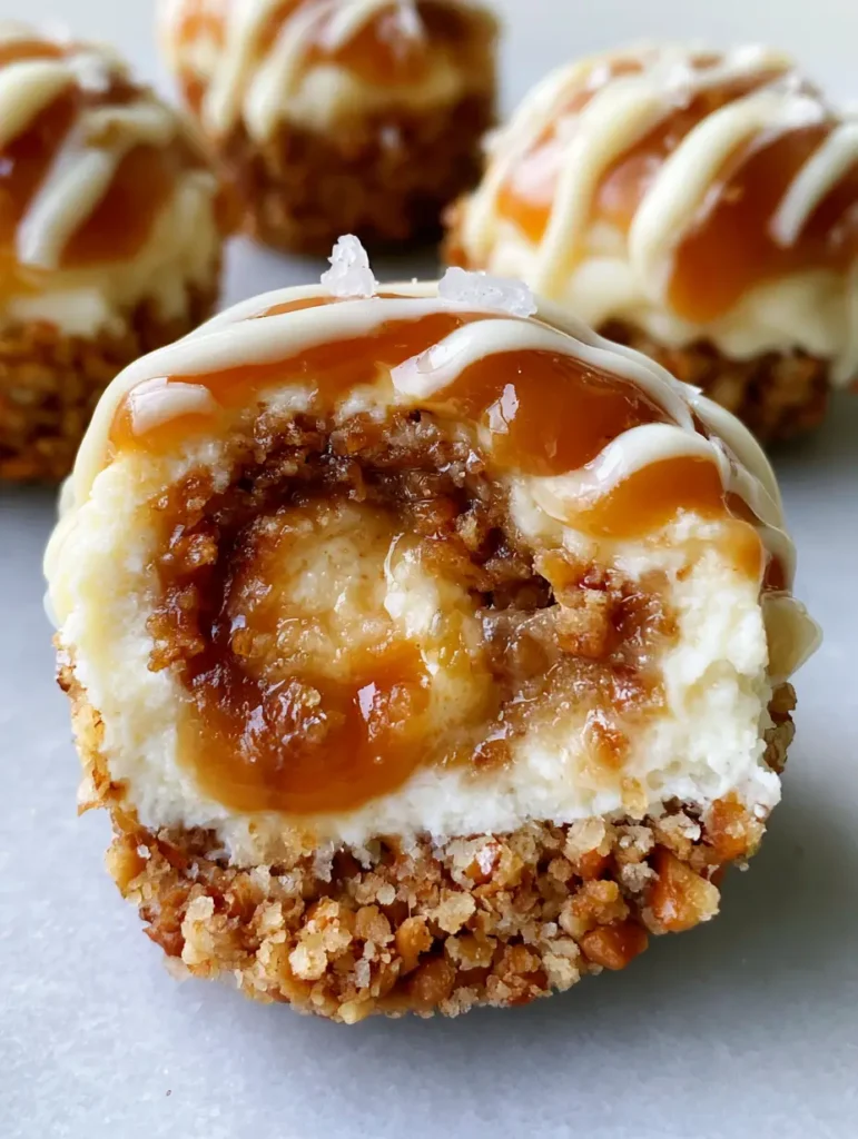 Ein Cheesecake-Bällchen in der Hand, deutlich sichtbar sind der Brezelboden, die cremige Füllung und das glänzende Karamell.