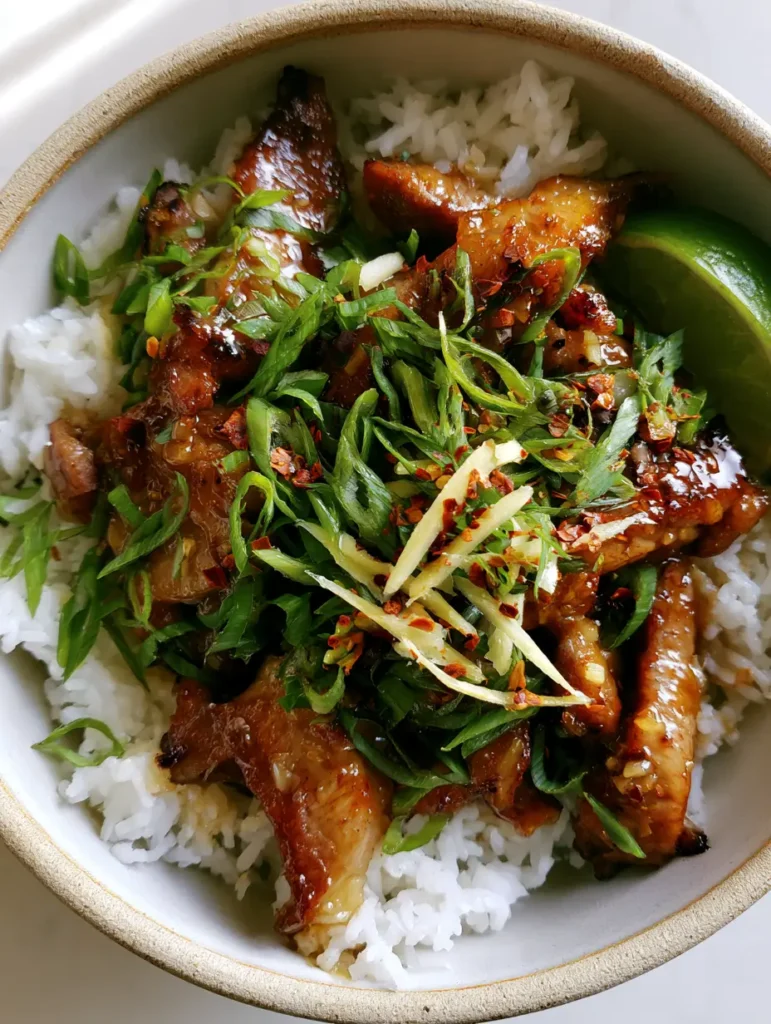 Ingwer-Limetten-Schwein: Das ultimative Asia-Rezept für Genießer 1 Draufsicht auf eine Schale mit Ingwer-Limetten-Schwein, frischem Ingwer und Limettenspalte.