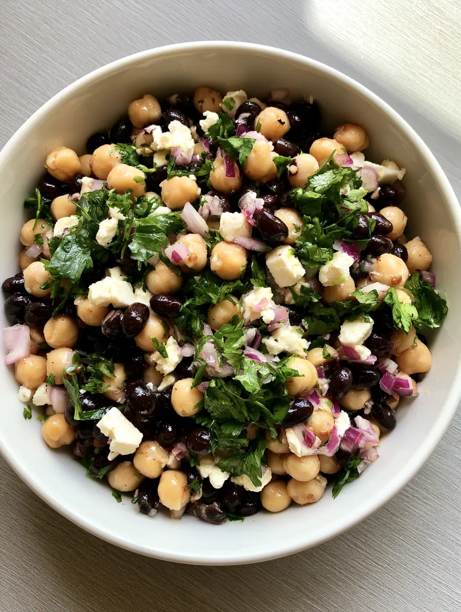 Kichererbsen-Schwarzbohnen-Salat: Das ultimative 10-Minuten-Rezept 3 Nahaufnahme von Kichererbsen, schwarzen Bohnen und Feta mit Limettendressing.