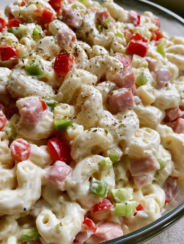 Cremiger Nudelsalat: Das ultimative Rezept für deine nächste Party 1 Cremiger Nudelsalat serviert in einer Schüssel auf einem neutralen Tisch.